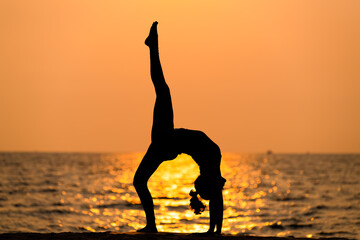 Sport woman yogini pose practice yoga exercise on sand beach near coconut palms in relaxing day , yoga is meditation and healthy sport concept