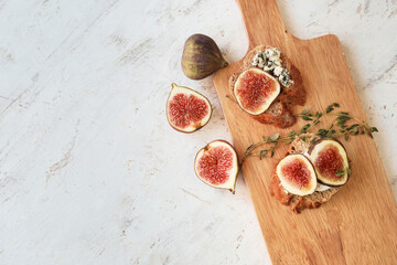 Tasty sandwiches with fig on light background