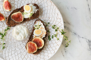 Tasty sandwiches with fig on light background