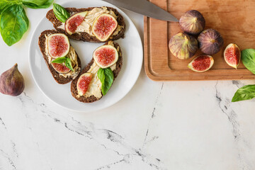 Tasty sandwiches with fig on light background