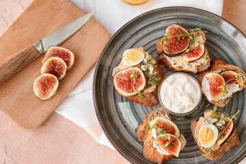 Tasty sandwiches with fig on color background