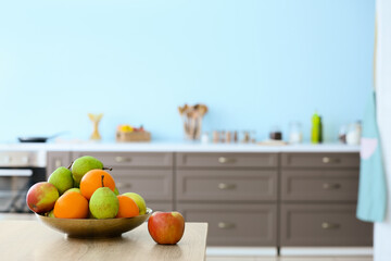 Plate with fruits on table in modern kitchen