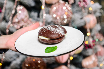 Delicious modern cocoa cake with chocolate and cream on a white plate. Served by waiter in restaurant or cafe