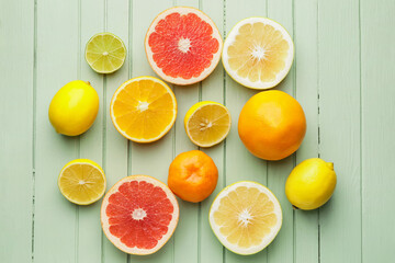 Cut citrus fruits on color wooden background