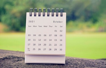 October 2021 white calendar with green blurred background