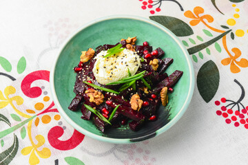 Beetroot salad with fresh greenery served in a bowl over traditional Ukrainian tablecloth.