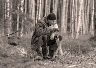 landscape with a forester in the woods by the fire, a worker drinks tea and warms up by the fire, sepia