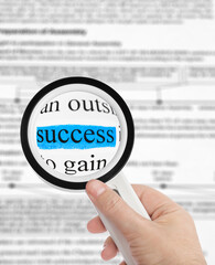 Magnifying glass in hand and word Success