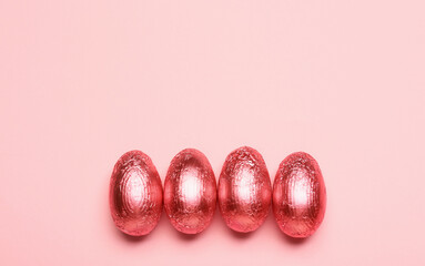 Sweet chocolate eggs on color background