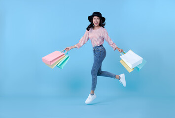Cheerful happy thai asian woman enjoying shopping,  she is carrying shopping bags and jumping to...