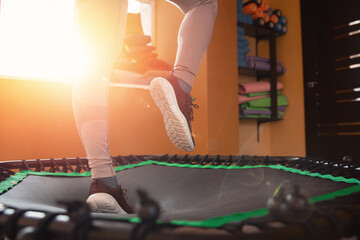 Closeup step fitness woman jumping on mobile mini trampoline