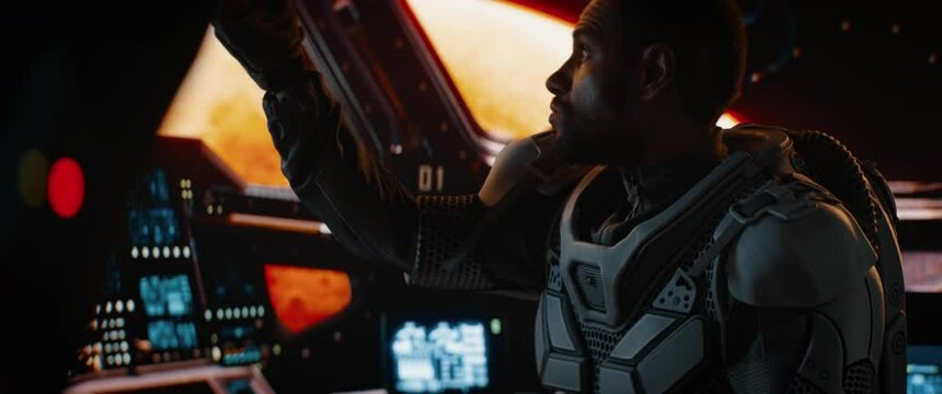 Portrait of African American Black male astronaut adjusting controls inside spaceship cockpit. Sci-fi space exploration concept. Mars mission. Shot with 2x anamorphic lens