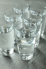 Shots with vodka on gray background, close up