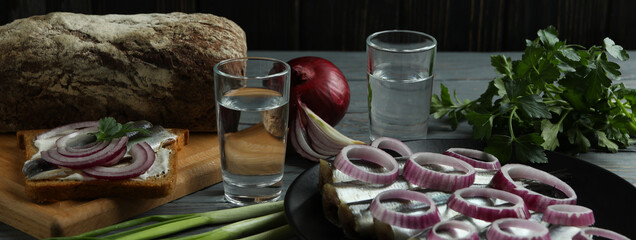 Shots of vodka and tasty snacks on wooden table