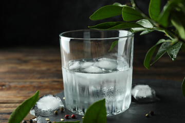 Glass of drink with ice on wooden table