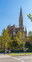 Sunny church on a tree-lined street in the city of Barcelona