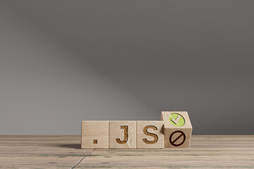 Wood cubes with acronym '.JS' on a beautiful wooden table, studio background. Business concept and copy space.