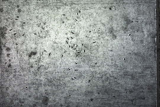 Scratches in a solid metal surface in neutral light.