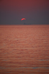 伊勢湾の鮮やかな夕焼けと海の日の入りの風景と海面の船の姿