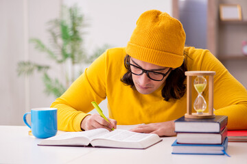 Young male student preparing for exams at home