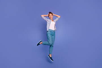Obraz premium Photo of funny impressed young lady dressed checkered jumping high arms head isolated purple color background