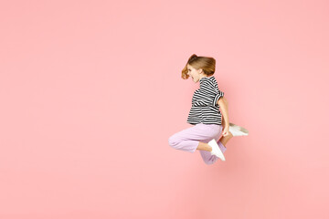Full length side view little blonde kid girl 12-13 year old in striped oversized t-shirt scream shouting jump high look aside isolated on pastel pink background children Childhood lifestyle concept - Powered by Adobe