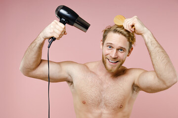 Smiling bearded naked young man 20s years old perfect skin hold blow dry hair with comb isolated on...