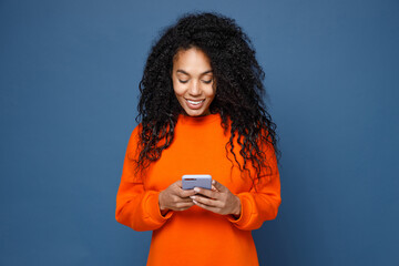 Smiling beautiful young african american woman wearing casual basic bright orange sweatshirt...