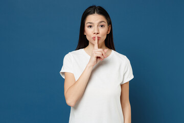 Young serious nice spanish latin woman 20s wear white casual basic t-shirt saying hush be quiet...