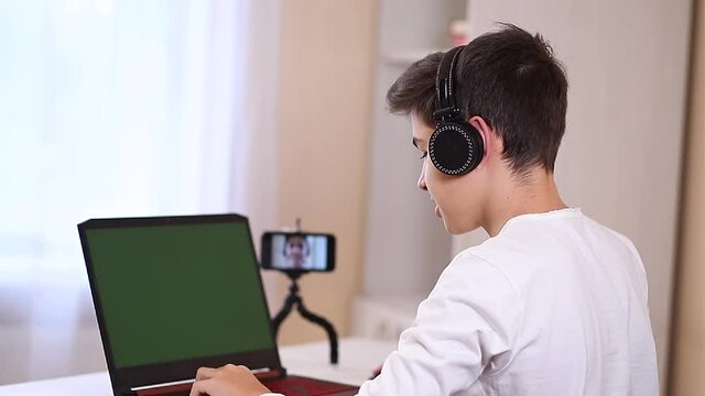Young teenage steamer stretch his fingers befour game. Boy play online games on his laptop at home