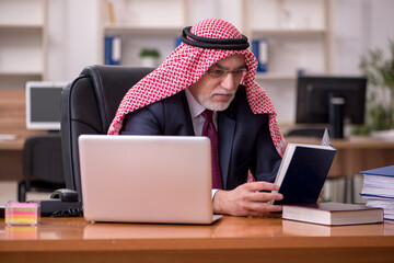 Aged arab businessman employee sitting at workplace