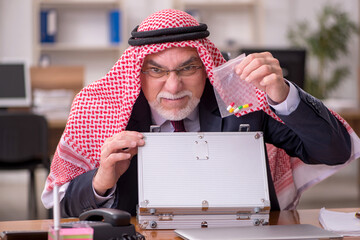 Aged arab businessman selling narcotics at workplace
