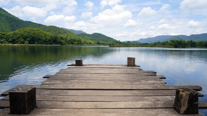 Empty wooden bridge or table top with the lake mountain and sky landscape. Wood floor with lake mountain and sky of nature park background and summer season, product display montage.
