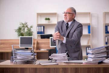 Fototapeta premium Old male employee unhappy with excessive work in the office
