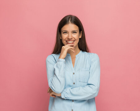 casual woman touching her chin, smiling and sending positive vibes