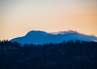 Camel's Hump Mountain silhouetted by setting sunlight  
