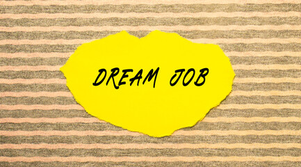 Yellow torn paper with the text DREAM JOB on a gray-pink background.