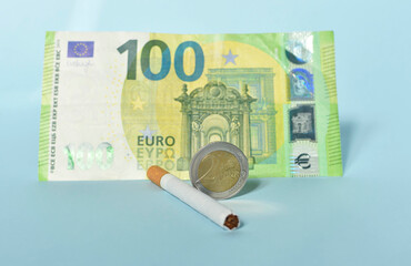 Cigarettes and money on blue background. Euro banknotes and coins, cost of smoking, cigarette price...