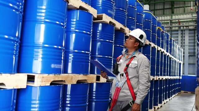 Cargo inspectors inspecting the number of chemical tanks in a ware house.