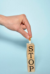 Stop smoking concept, hand extinguishing a cigarette and STOP text on wooden blocks. World No...