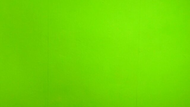 Human hands hold and clap with clapperboard. Beginning of scene in film or television production. Green screen. Chrome key. Close-up.