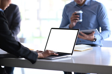 Cropped shot of businesspeople working with computer laptop and discussing the situation on the market at meeting room.