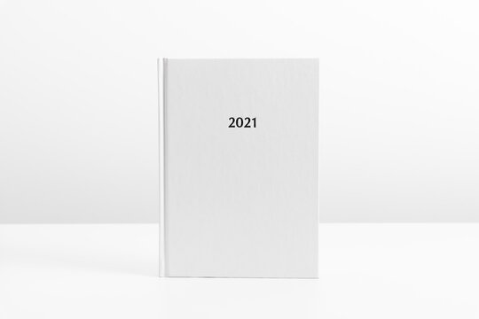 White book mockup, diary for 2021, white table. Front view. Place for text, copy space, mockup