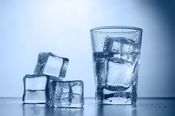 Misted glass shot with chilled vodka and ice cubes.