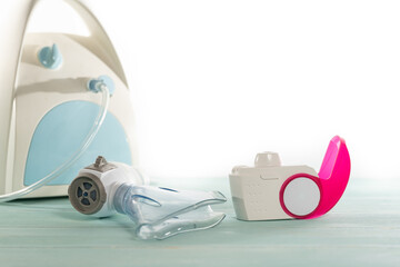 Set of asthma inhaler and aerosol machine with inhaler mask,concept asthma and treatment on green background,copy space.