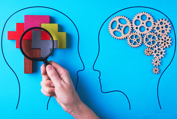 Human brain is made gear mechanism and colourful shapes on blue background. The brain is viewed through a magnifying glass. T