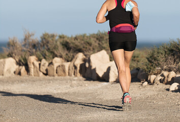Sportive woman take off protective mask while jogging for easier breathing on road due to the...