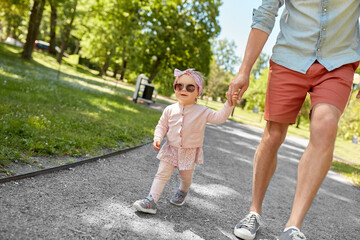 Obraz premium family, fatherhood and people concept - father with baby daughter walking at summer park