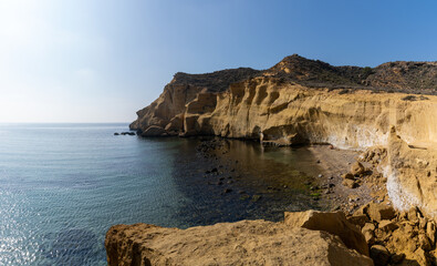 Fototapeta na wymiar calm idyllic ocean water in the Mediterranean with yellow sandstone cliffs behind