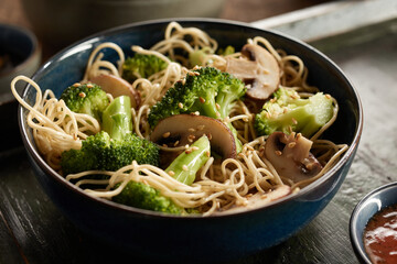 Bowl of delicious pasta with mushrooms and broccoli